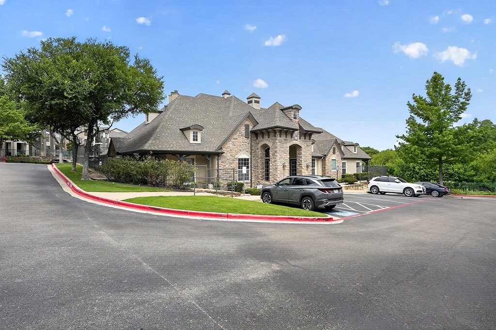 A large house with a grey car parked in front.